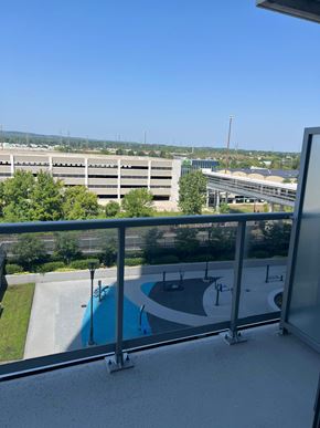 Burlington apartment for rent - A view from a balcony overlooking a pool and a parking lot.