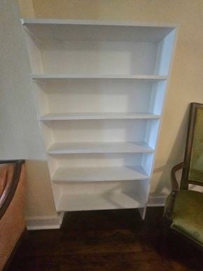 Pensacola house for rent - A white shelf with five shelves is in a corner.