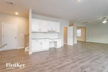 Lexington house for rent - A spacious kitchen with white cabinets and a wooden floor.