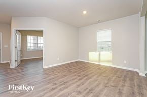 Lexington house for rent - A spacious empty room with wooden flooring and a doorway leading to another room.