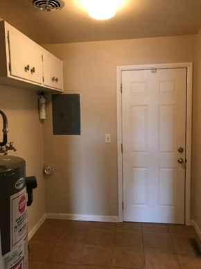 Lima house for rent - A white door is in a room with a trash can and a cabinet.