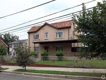 Washington apartment for rent - A house with a red tile roof and a fence in front.