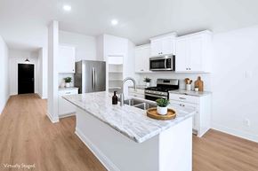 Greenville house for rent - A kitchen with white cabinets and a marble countertop.