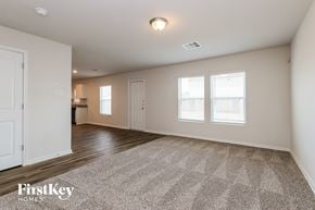 Conroe house for rent - A spacious room with a carpeted floor and two windows.