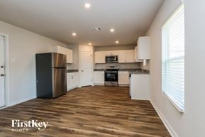 Conroe house for rent - A kitchen with a refrigerator, oven, and microwave.