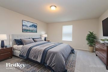 Conroe house for rent - A bedroom with a large bed and a painting on the wall.