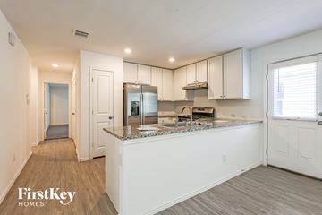 New Braunfels house for rent - A kitchen with white cabinets and a granite countertop.