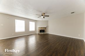 Rockwall house for rent - A spacious room with a fireplace and a ceiling fan.