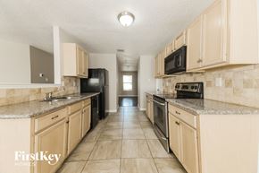 Rockwall house for rent - A kitchen with beige cabinets and a tiled floor.