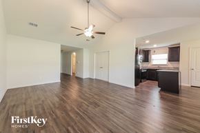 Dallas house for rent - A spacious room with wooden flooring and a ceiling fan.