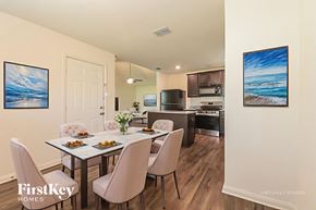 Dallas house for rent - A dining room with a table set for two and a kitchen in the background.
