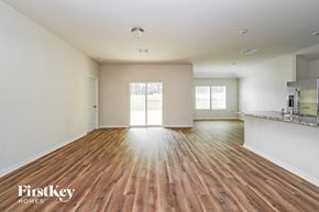 Conroe house for rent - A spacious room with wooden floors and a large window.