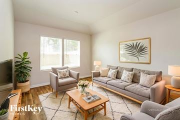 Conroe house for rent - A living room with a grey couch, a wooden coffee table, and a painting on the wall.