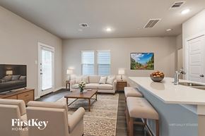 Shenandoah house for rent - A modern living room with a large couch, a coffee table, and a flat-screen TV.