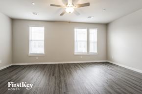 Shenandoah house for rent - A spacious room with a ceiling fan and wooden flooring.