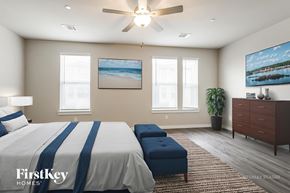 Shenandoah house for rent - A bedroom with a bed, a bench, a ceiling fan, and a painting on the wall.