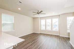 Shenandoah house for rent - A spacious room with a ceiling fan and wooden flooring.