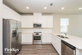 Shenandoah house for rent - A kitchen with a stainless steel refrigerator, microwave, oven, and dishwasher.