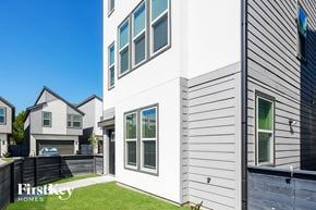 Shenandoah house for rent - A modern house with a grey siding exterior and a white garage door.