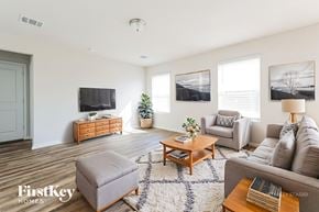 Conroe house for rent - A living room with a grey couch, a coffee table, and a flat screen TV.