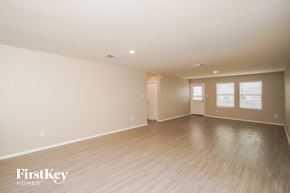 New Braunfels house for rent - A spacious room with wooden flooring and white walls, with a window on the right wall.