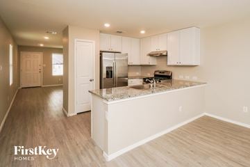 New Braunfels house for rent - A kitchen with a white island and wooden floors.