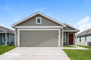 New Braunfels house for rent - A house with a garage door and a red door is for sale.