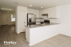 New Braunfels house for rent - A kitchen with white cabinets and a wooden floor.