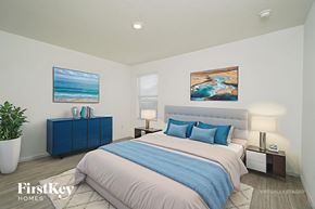 New Braunfels house for rent - A bedroom with a bed, nightstands, and two paintings on the wall.