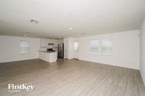 New Braunfels house for rent - A spacious, empty room with wooden flooring and white walls.