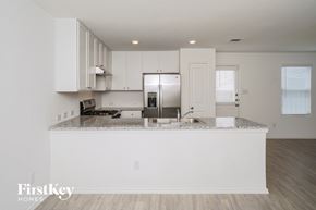 New Braunfels house for rent - A kitchen with white cabinets and a granite countertop.