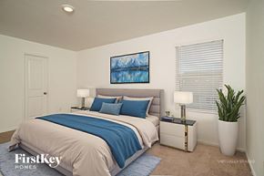 New Braunfels house for rent - A bedroom with a bed, nightstand, and a painting on the wall.