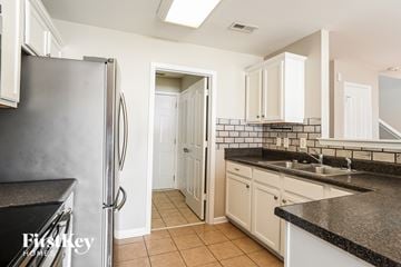 Charlotte house for rent - A kitchen with a black granite countertop and white cabinets.