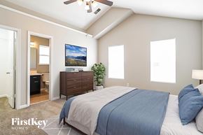 Charlotte house for rent - A bedroom with a bed, dresser, and ceiling fan.