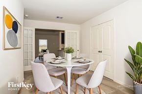 Magnolia house for rent - A dining room with a white table and chairs.