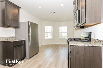 Magnolia house for rent - A kitchen with wooden cabinets and a granite countertop.