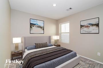 Baytown house for rent - A bedroom with a large bed and two pictures on the wall.