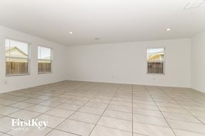 Princeton house for rent - A spacious empty room with tiled flooring and three windows.