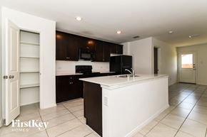 Princeton house for rent - A kitchen with a black fridge and white countertops.