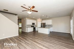 North Richland Hills house for rent - A spacious kitchen and living room with a ceiling fan and hardwood floors.