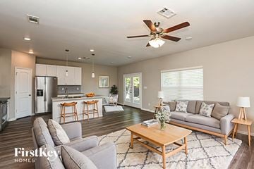North Richland Hills house for rent - A well-lit living room with a grey sofa and a wooden coffee table.