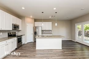 North Richland Hills house for rent - A kitchen with white cabinets and a wooden floor.