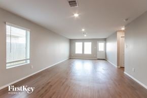 Baytown house for rent - A spacious room with wooden floors and white walls.