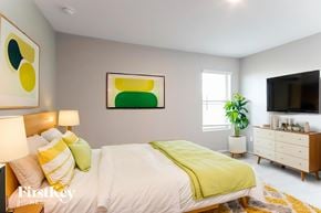 Baytown house for rent - A bedroom with a bed, nightstand, and a painting on the wall.