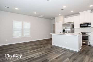 Shenandoah house for rent - A kitchen with white cabinets and a wooden floor.