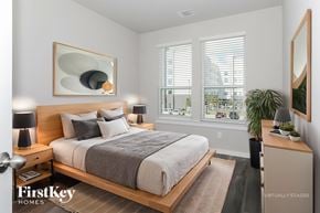 Shenandoah house for rent - A bedroom with a large bed, a nightstand, and a mirror on the wall.