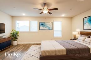 Shenandoah house for rent - A bedroom with a bed, a ceiling fan, and a painting on the wall.