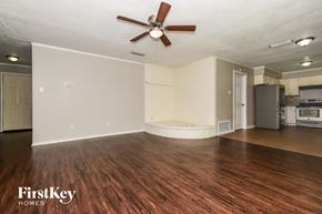 Rockwall house for rent - A spacious room with a wooden floor and a ceiling fan.
