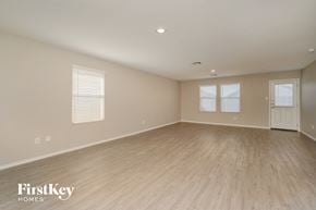 New Braunfels house for rent - A spacious room with wooden flooring and a door on the right side.