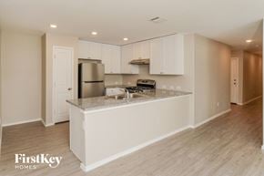 New Braunfels house for rent - A kitchen with white cabinets and a granite countertop.